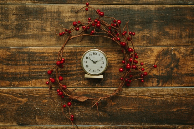 Old golden alarm clock with red berries